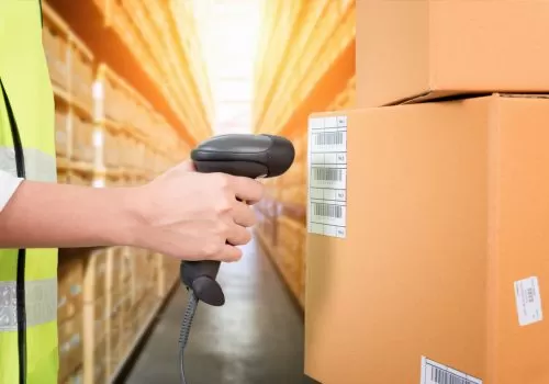 Woman scanning barcode from a label in modern warehouse